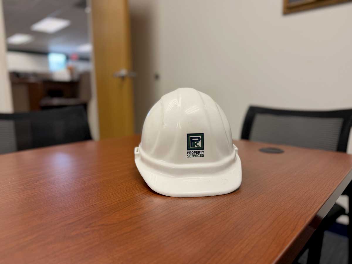 White hard hat with company logo on table