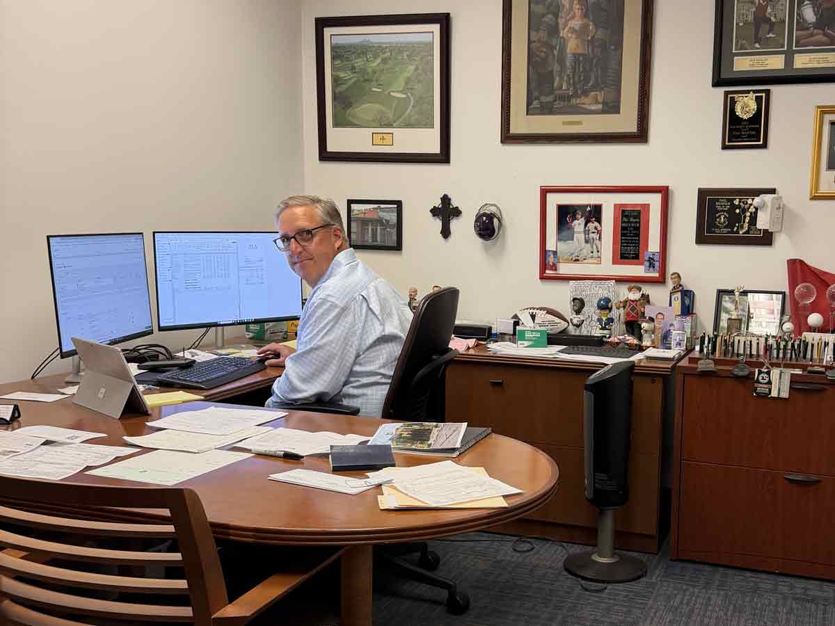 Man working at office desk with dual monitors