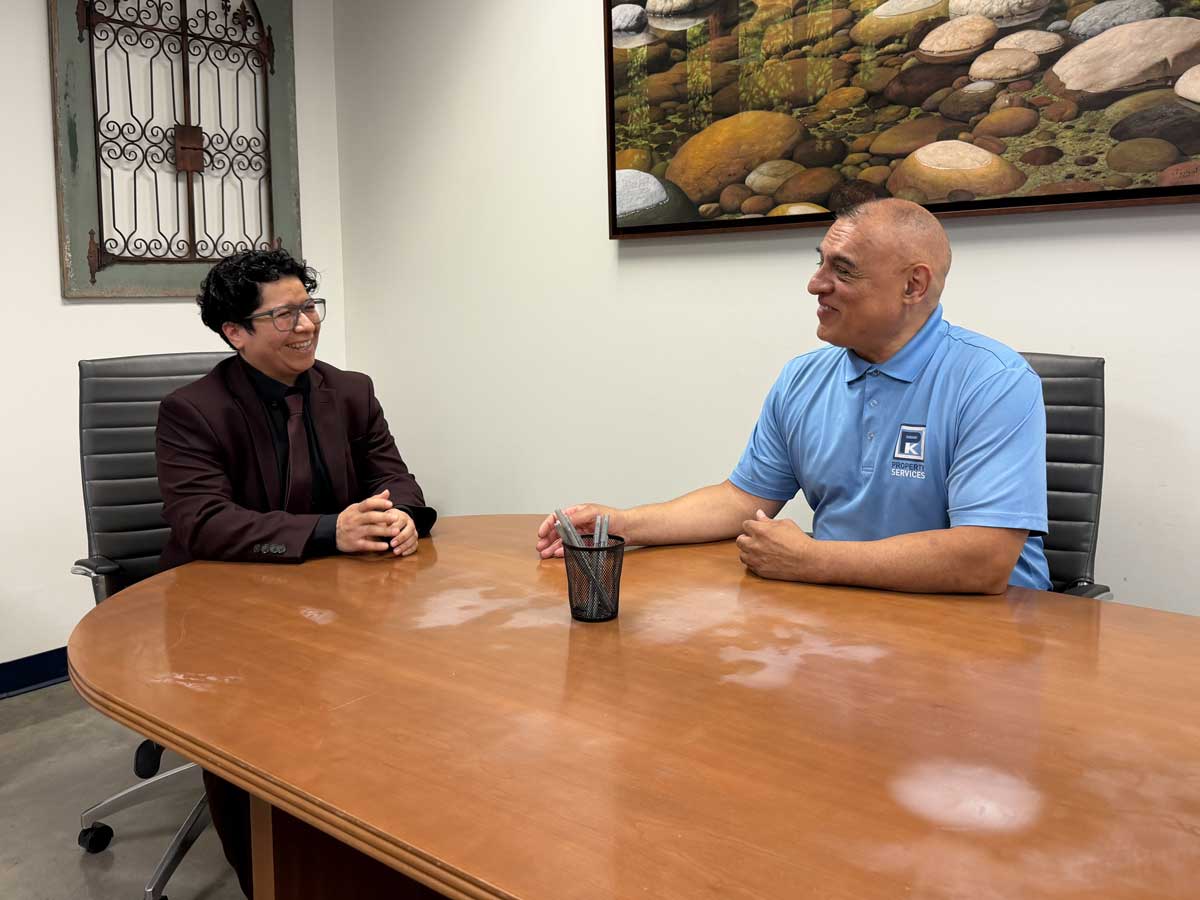 Two men talking at office conference table