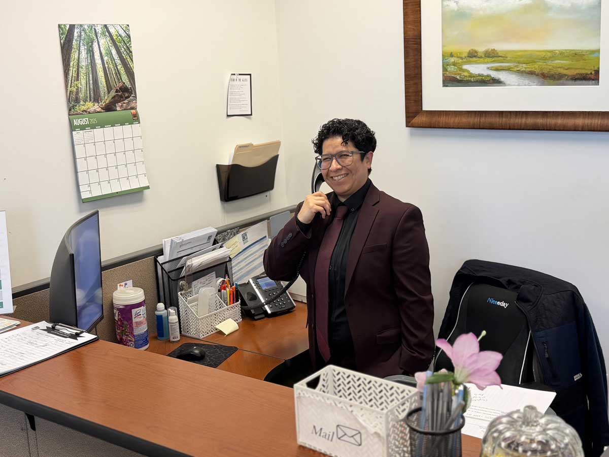 Office worker smiling while talking on desk phone